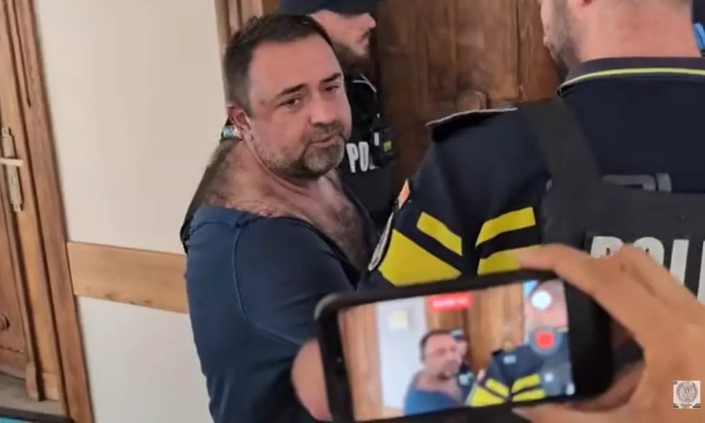 Cazul procurorului care a intrat cu pistolul într-un local. Cine a tras, de fapt, cu arma / Critici după ce a fost adus în instanță într-un tricou rupt
